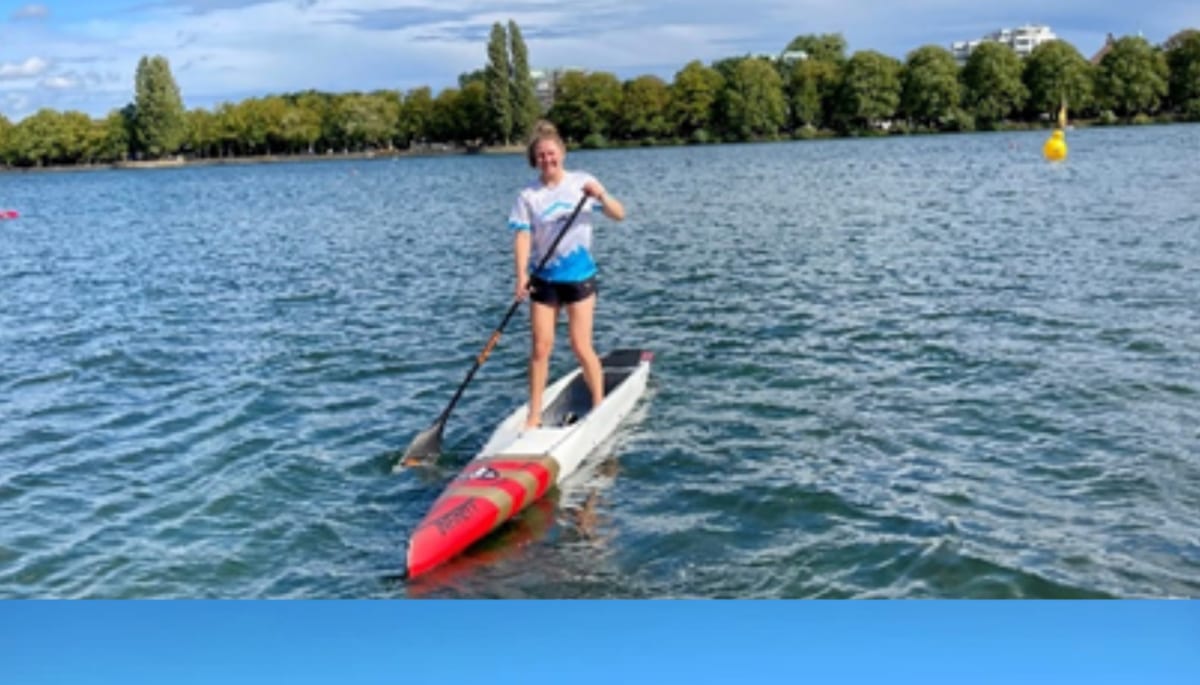 Teammitglied beim Stand-Up-Paddling auf einem See